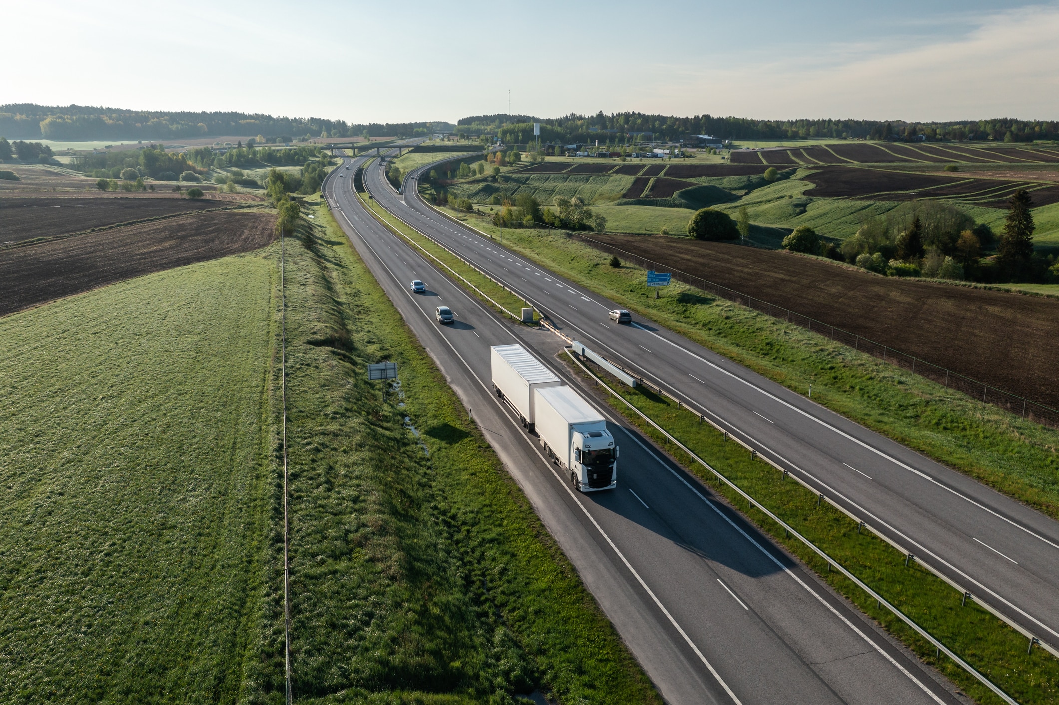 lastbil kör på landsväg med gröna landskap. Vägar skapas av byggnadsingenjörer inom infrastruktur